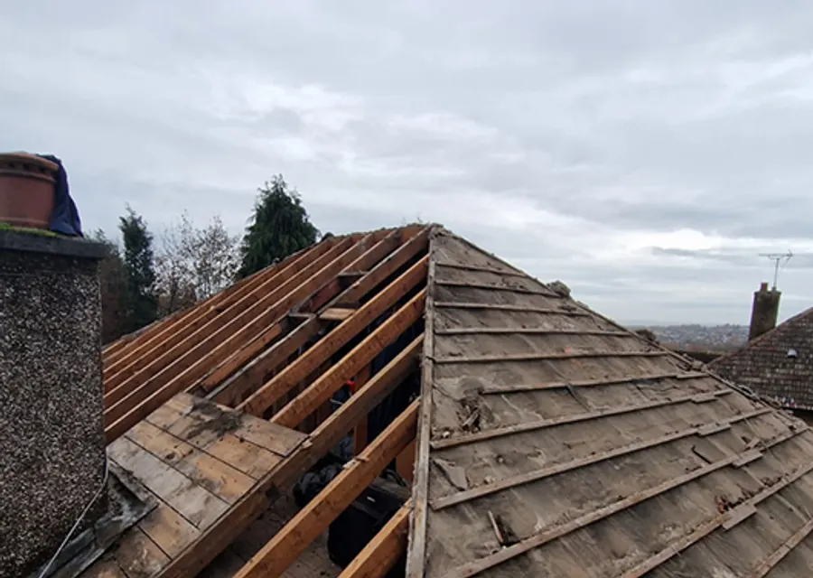 Roofers repairing a pitched roof